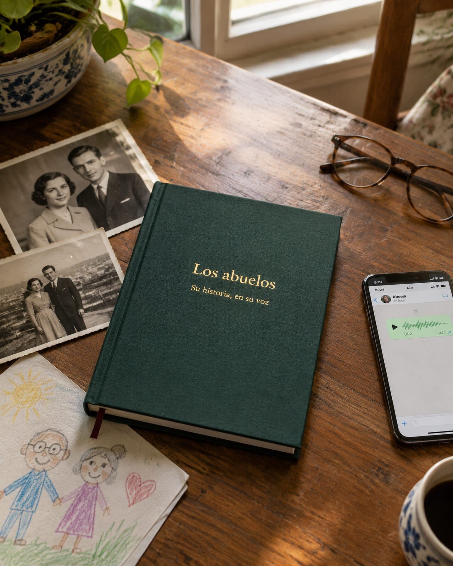 Un libro de tapa dura verde titulado «Los abuelos» junto a fotografías en blanco y negro, el dibujo de un nieto y un móvil con una nota de voz.